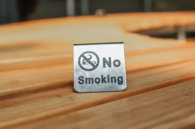 a small, metal no smoking sign on a table