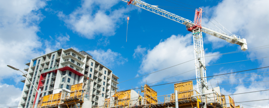 Photo of building under construction with crane overhead