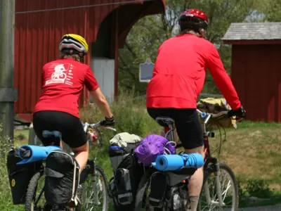 Two cyclists are cycling towards a covered bridge