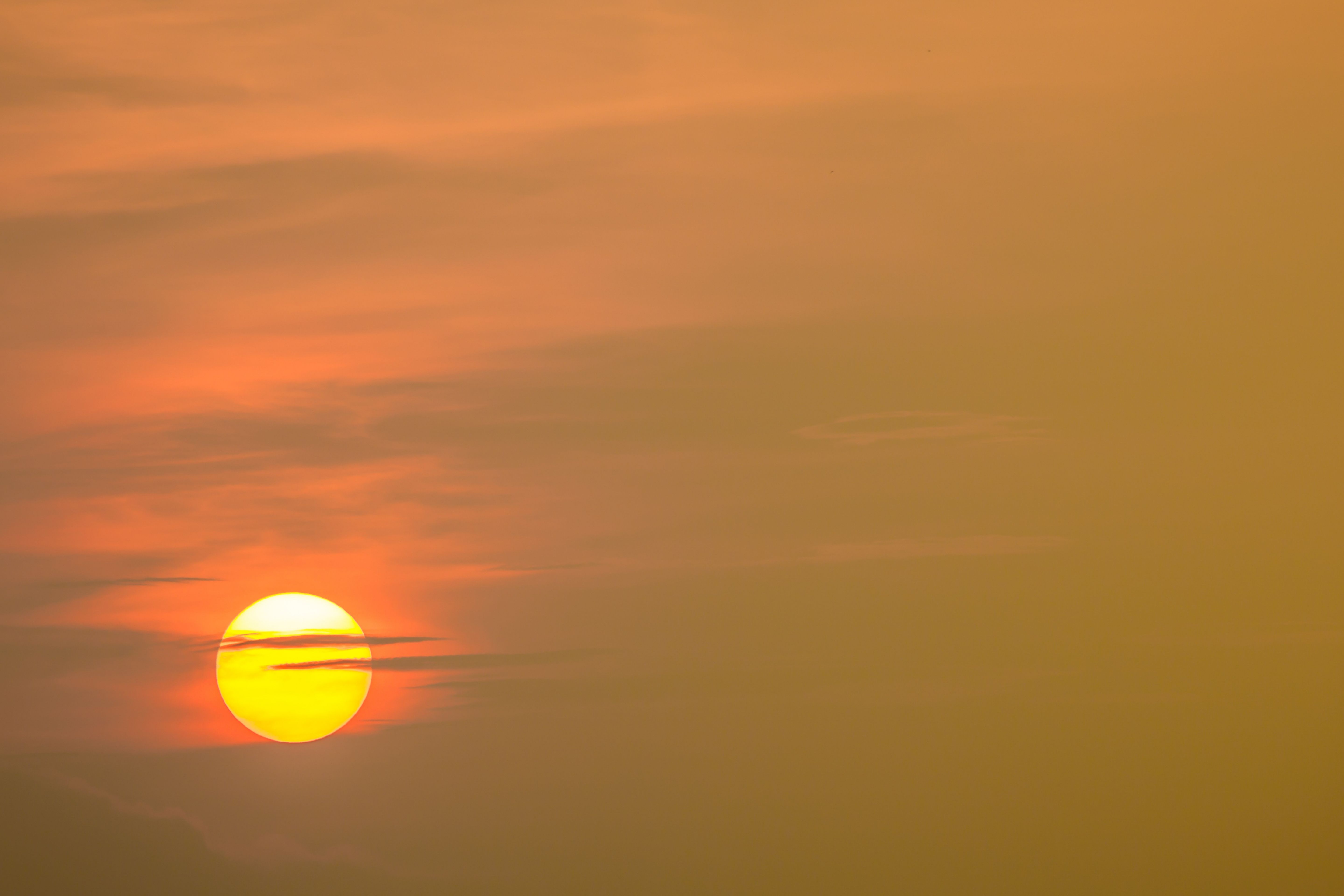 a sun setting in a hazy sky