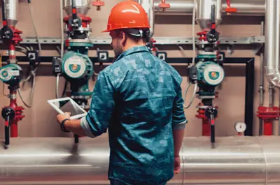 A worker inspects pipes at a water treatment plant