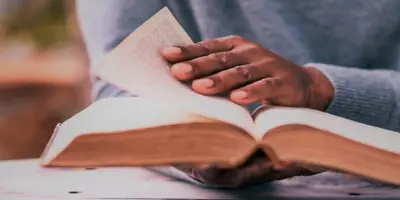 Close-up view of hands turning the page of a book